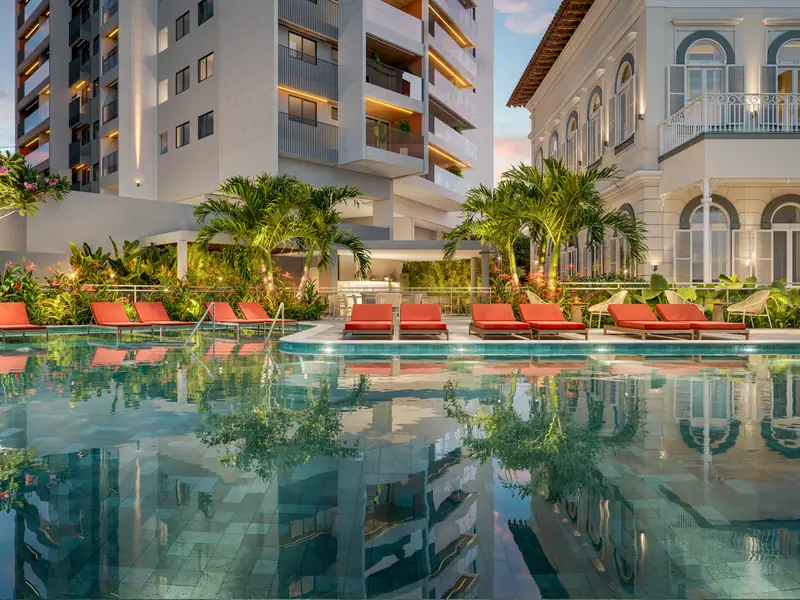 Piscina com raia de 25 metros rodeada por paisagismo tropical de Benedito Abbud e espreguiçadeiras modernas.